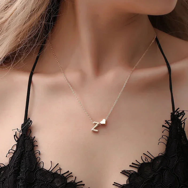 Collana minimal con piccolo ciondolo a cuore e lettera personalizzata, disponibile in oro o argento. Un accessorio delicato perfetto come regalo elegante per lei.