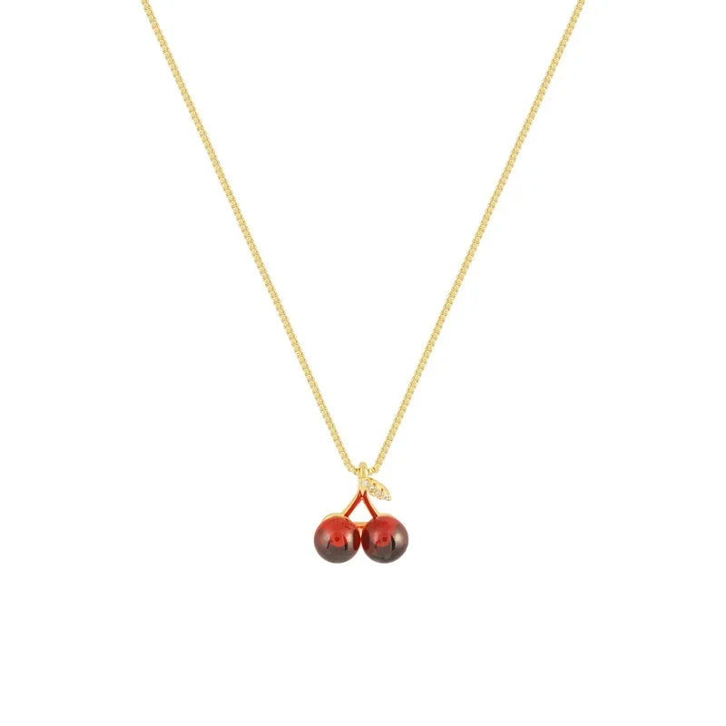 Collana dorata con ciondolo a ciliegia rosso vino, femminile e vivace, perfetta per feste e come regalo.