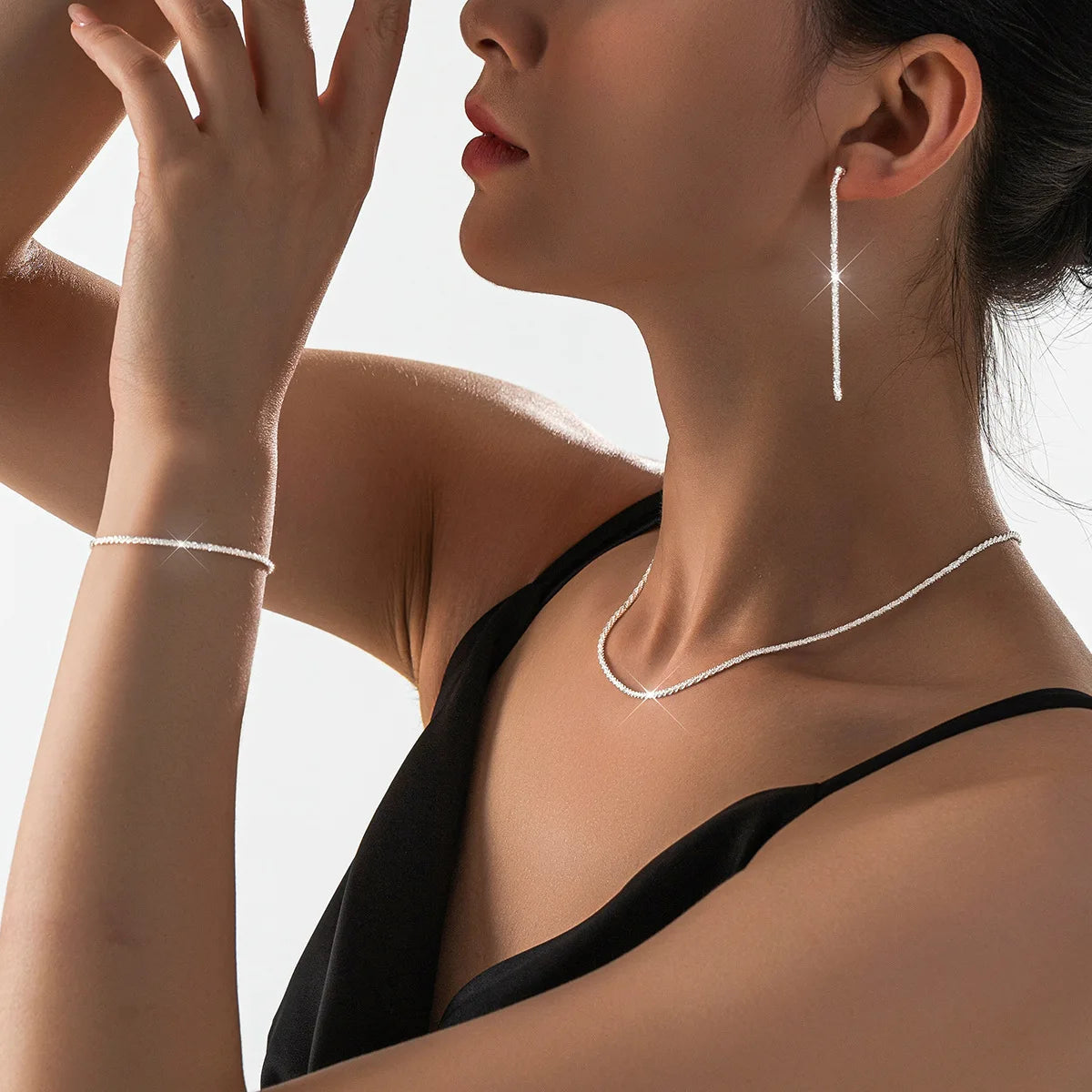 Set di collana e bracciale placcati argento, design minimal con dettagli ispirati al cielo stellato. Accessori eleganti perfetti per un look femminile raffinato.